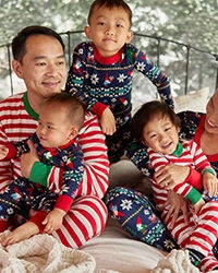 family sitting wearing coordinating family pajamas
