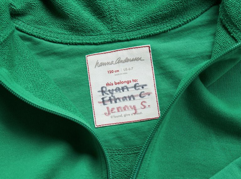 a green hoodie showing multi names crossed out