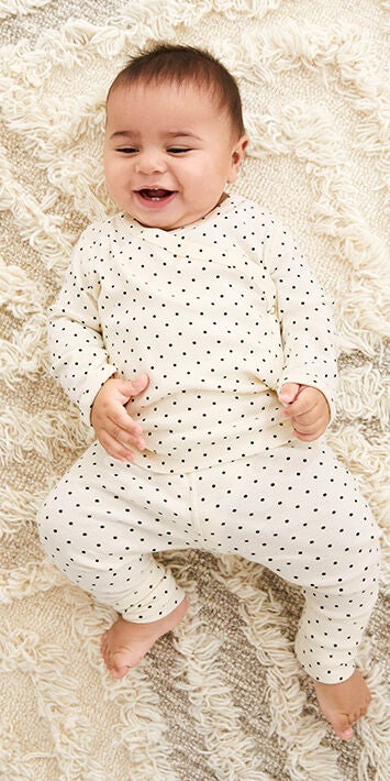 baby in white polka dot wiggle set
