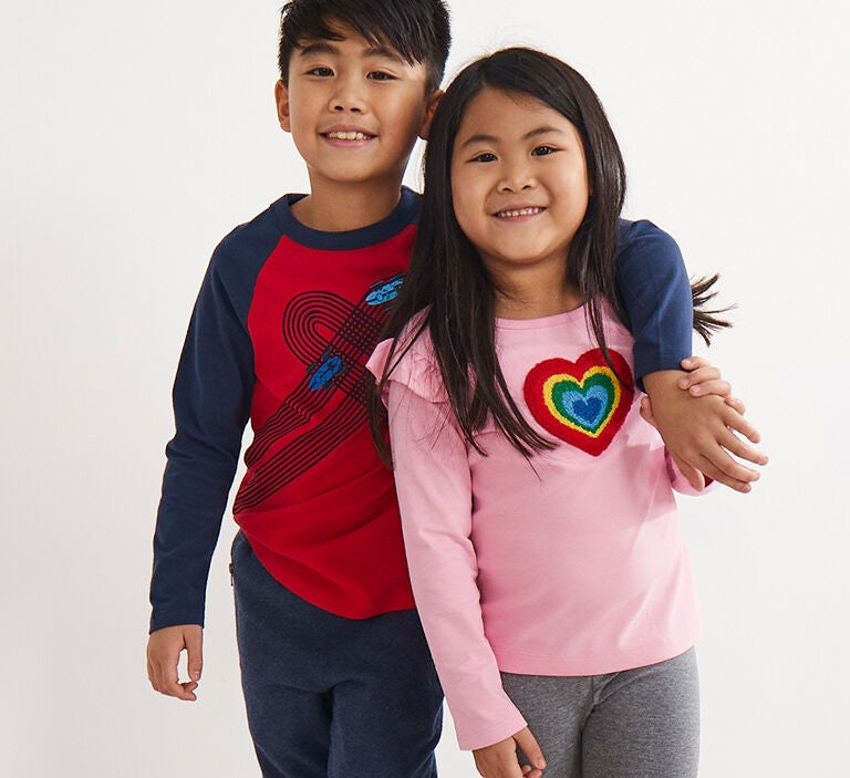 A boy and a girl wearing Valentines Day long sleeve shirts