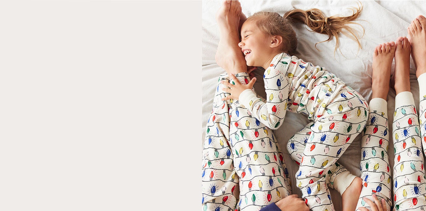 family wearing matching christmas lights print pajamas