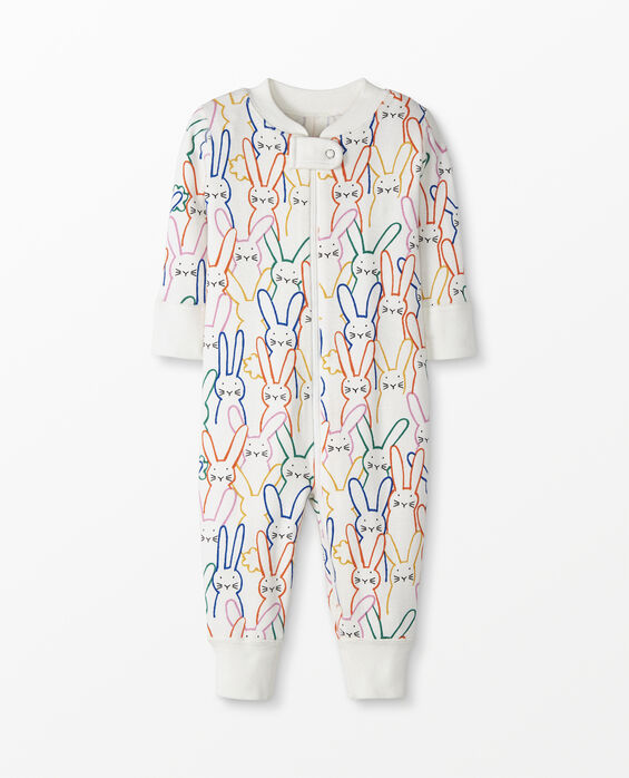  white zip up baby sleeper with rainbow bunny pattern