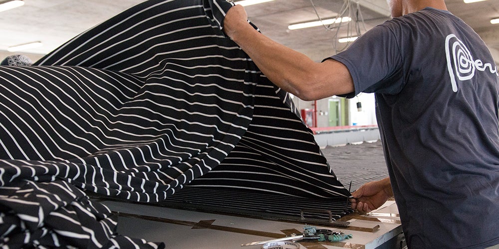 Image of worker measuring and cutting Hanna Andersson fabric. Image of worker measuring and cutting Hanna Andersson fabric.