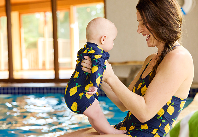 mom holding baby wearing matching lemon swimsuits
