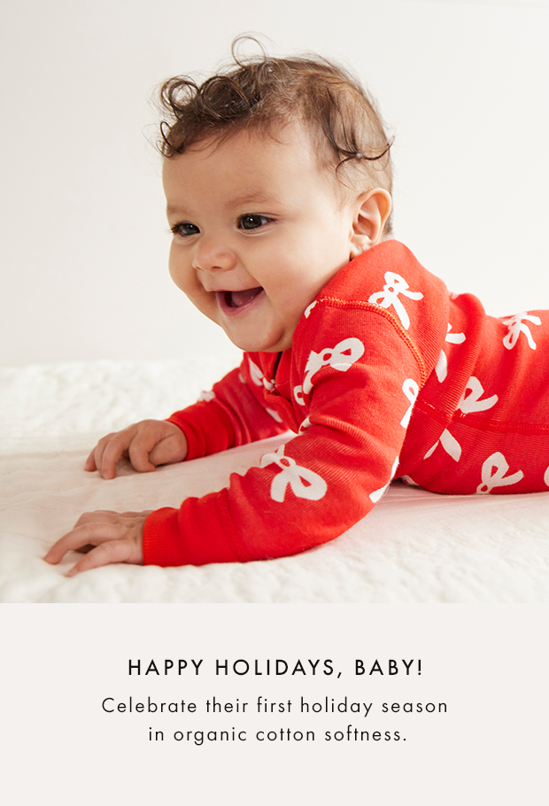 baby laying down wearing a holiday sleeper