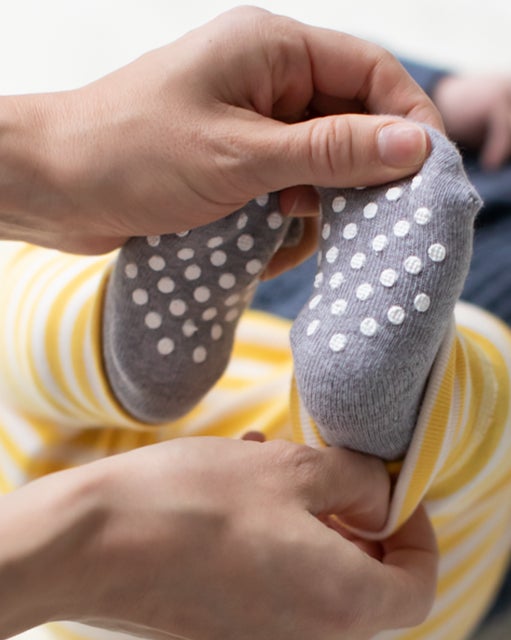 parent putting socks on baby