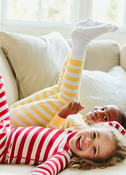 kids on couch wearing stripe pajamas