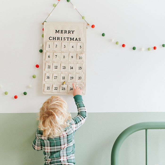 Toddler looking at calendar wearing holiday pajamas