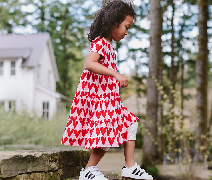 Image of child walking down rock staircase in a Hanna Andersson dress.