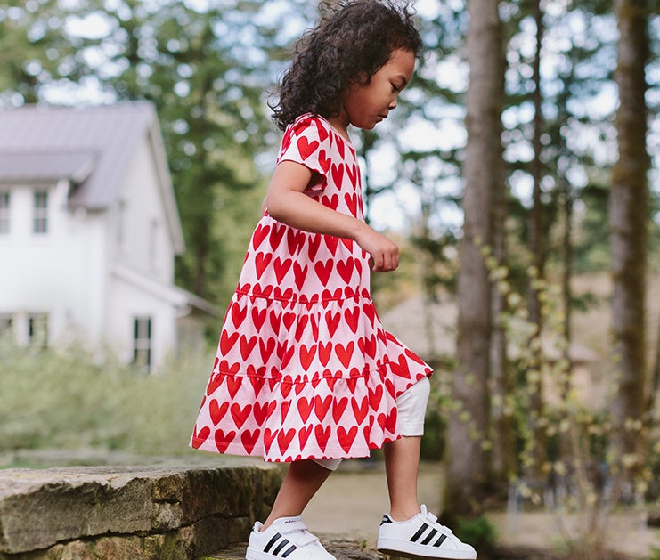 Image of child walking down rock staircase in a Hanna Andersson dress. Image of child walking down rock staircase in a Hanna Andersson dress.