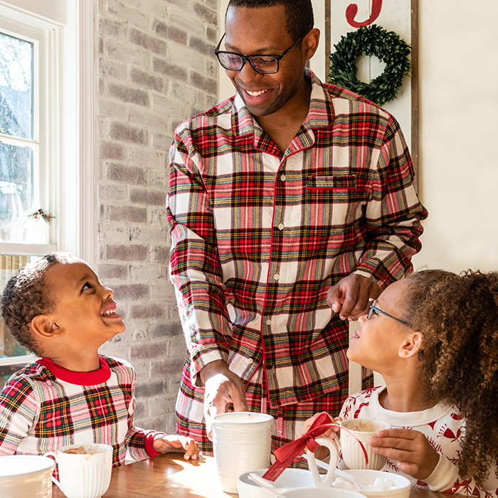 Family drinking hot cocoa in matching holiday pajamas